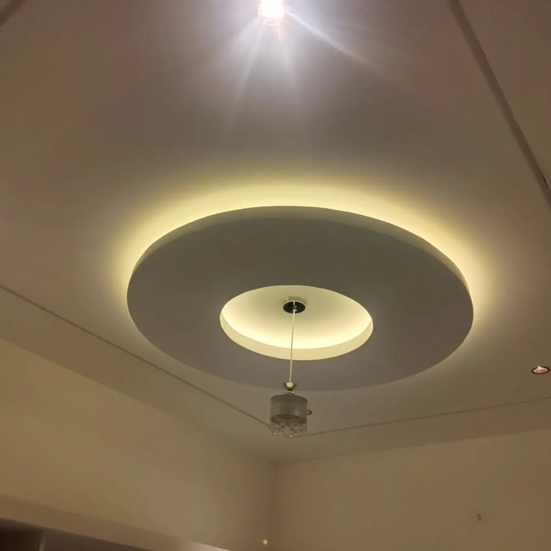 Gypsum false ceiling with a cove-lit border in a Forbesganj living room by JK Interior