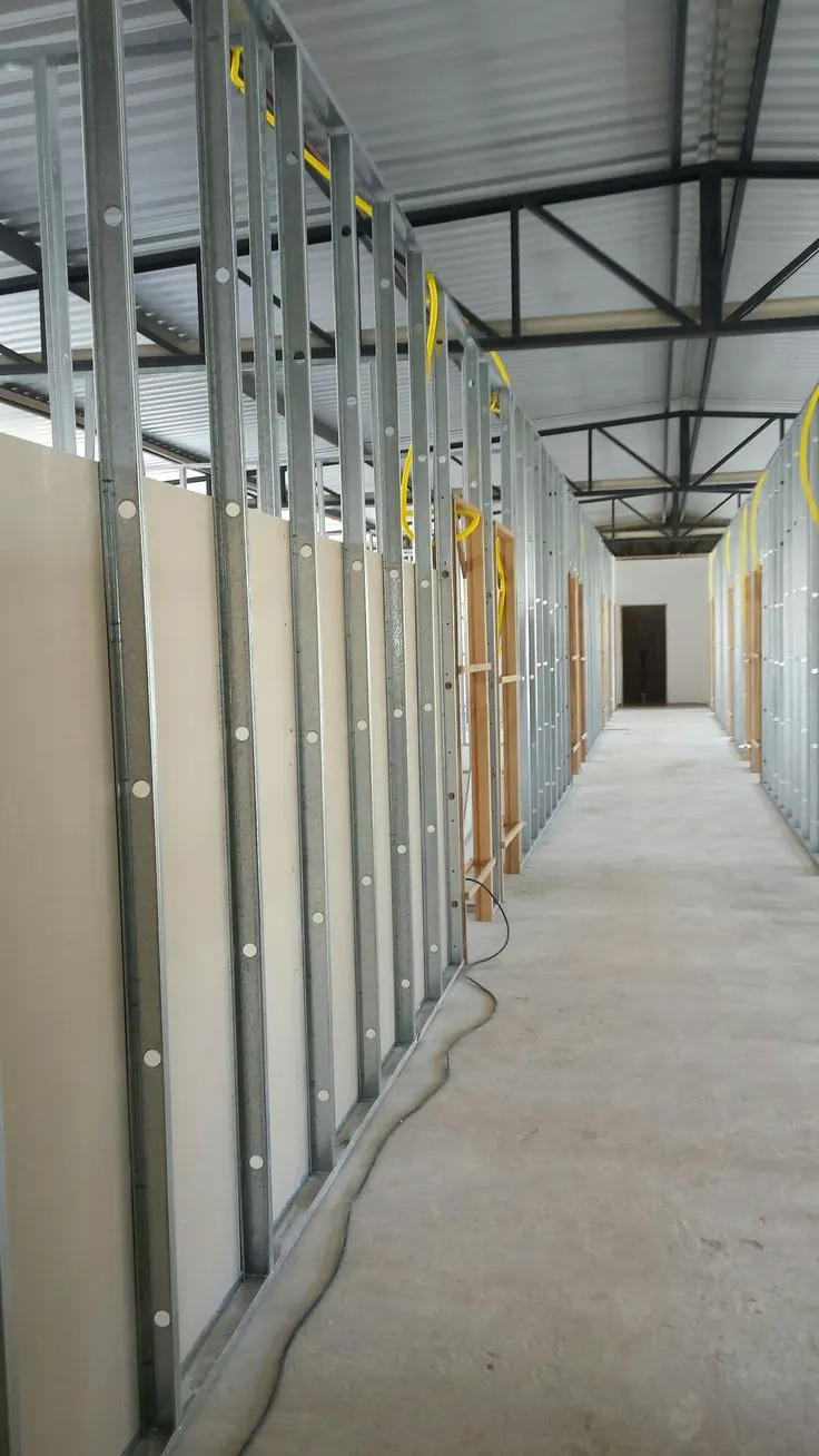 Row of gypsum partition cabins under a steel-truss roof Row of gypsum partition cabins under a steel-truss roof